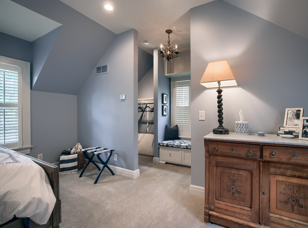 Interior room featuring light gray walls, a cozy reading nook with a blue cushion, a wooden dresser, and a stylish lamp, showcasing professional interior painting services by Copeland Painting.