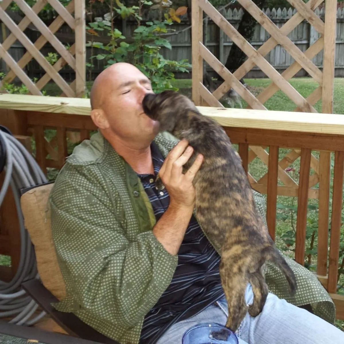 Karl and a puppy getting puppy breath kisses