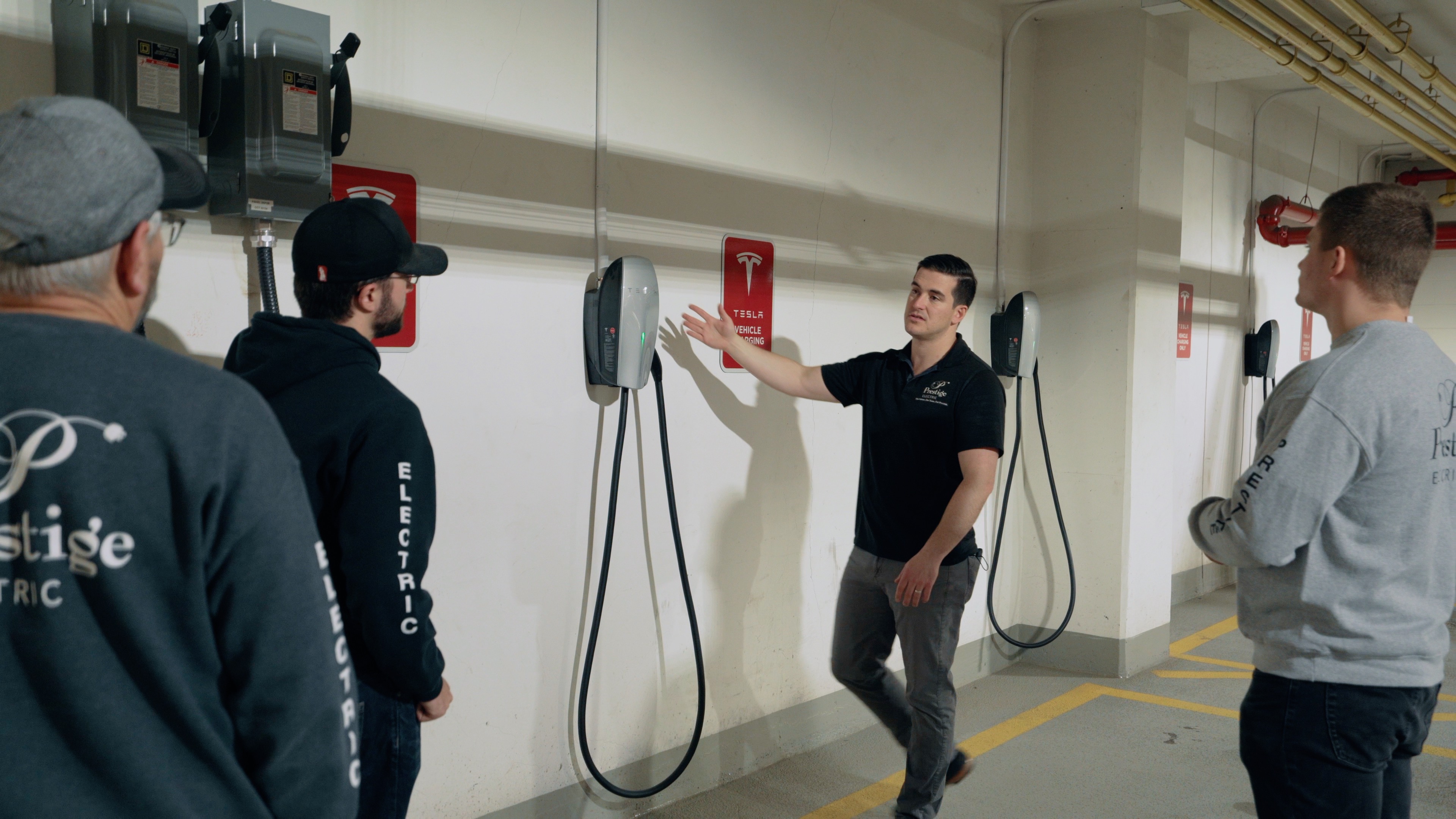 Prestige Electric team members inspecting a commercial EV charger