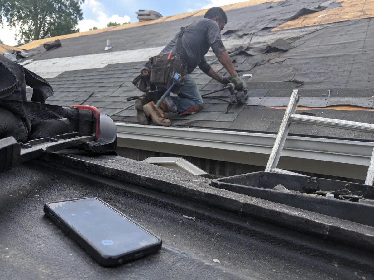 Roofing contractor on a job while AI handles incoming leads