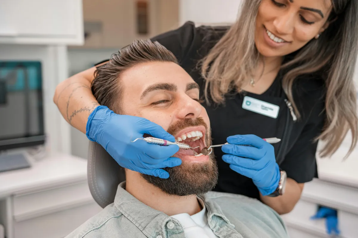 Man getting teeth cleaned by dentist