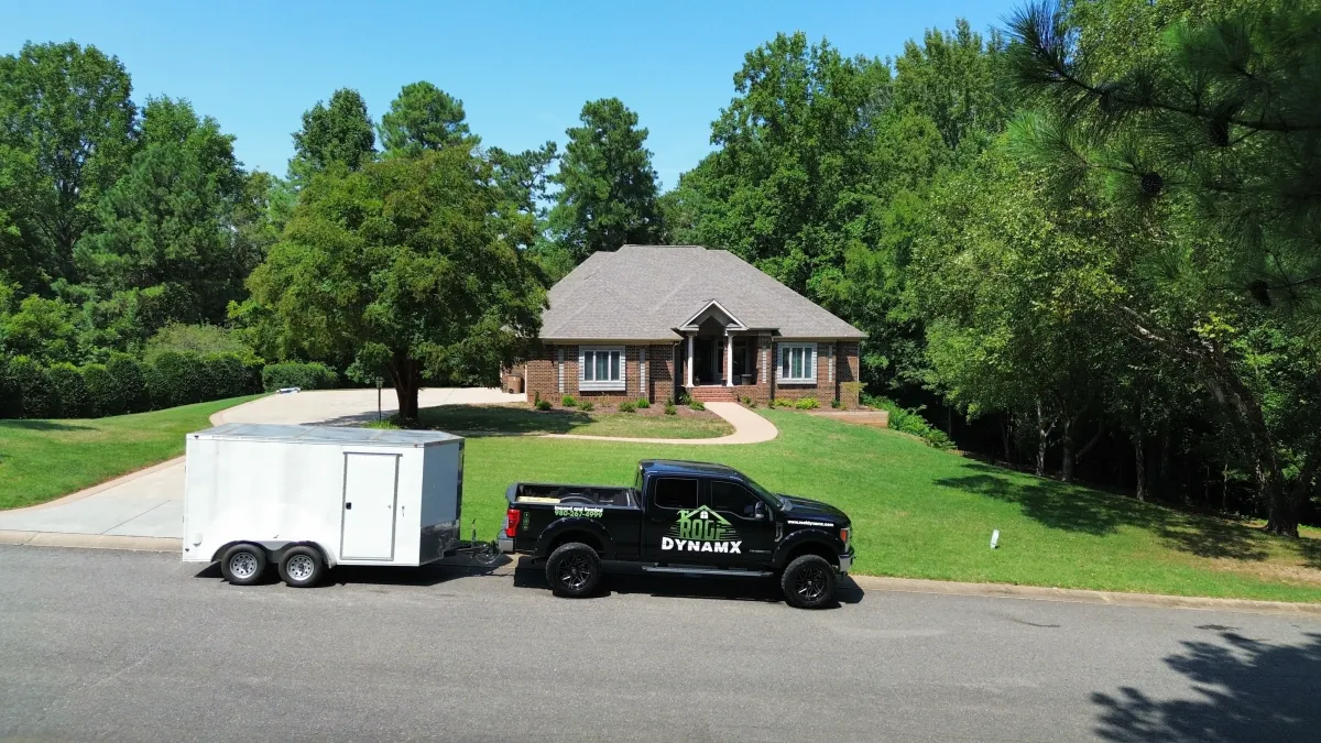 a roof dnamx truck in front of a house