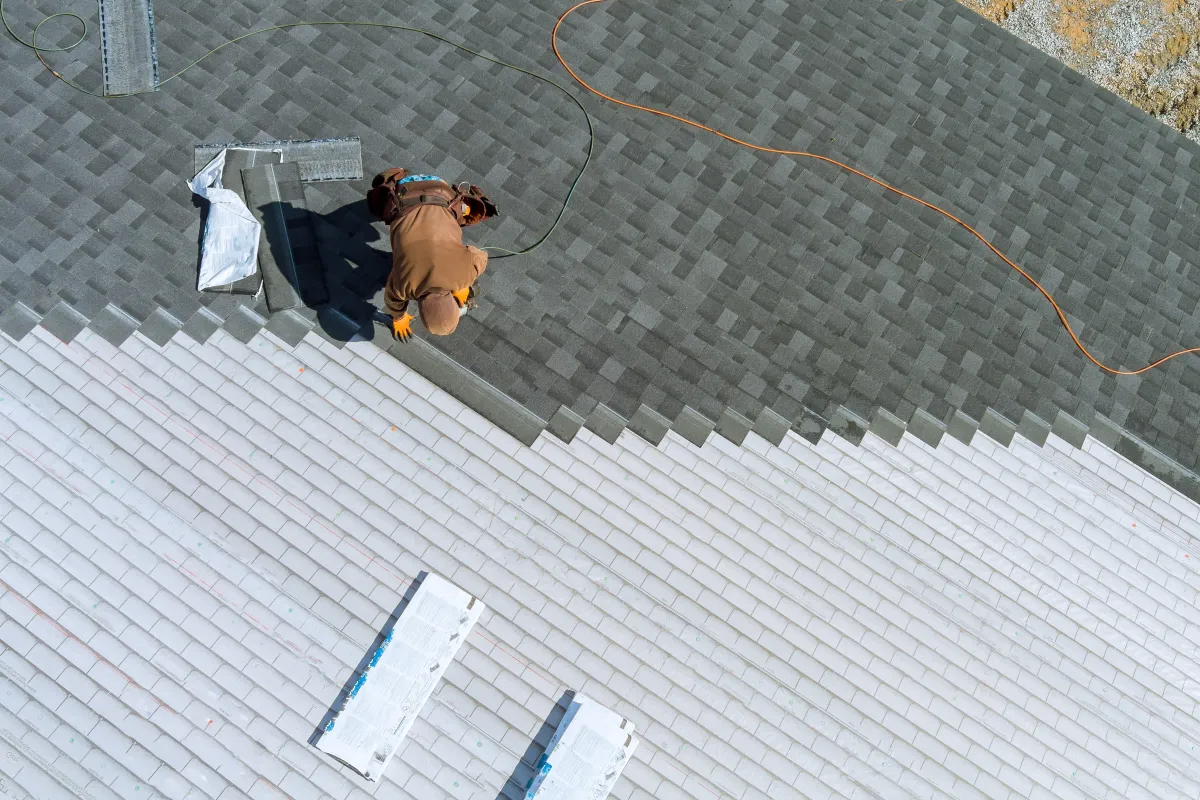 an expert roofer installing a shingle roofing