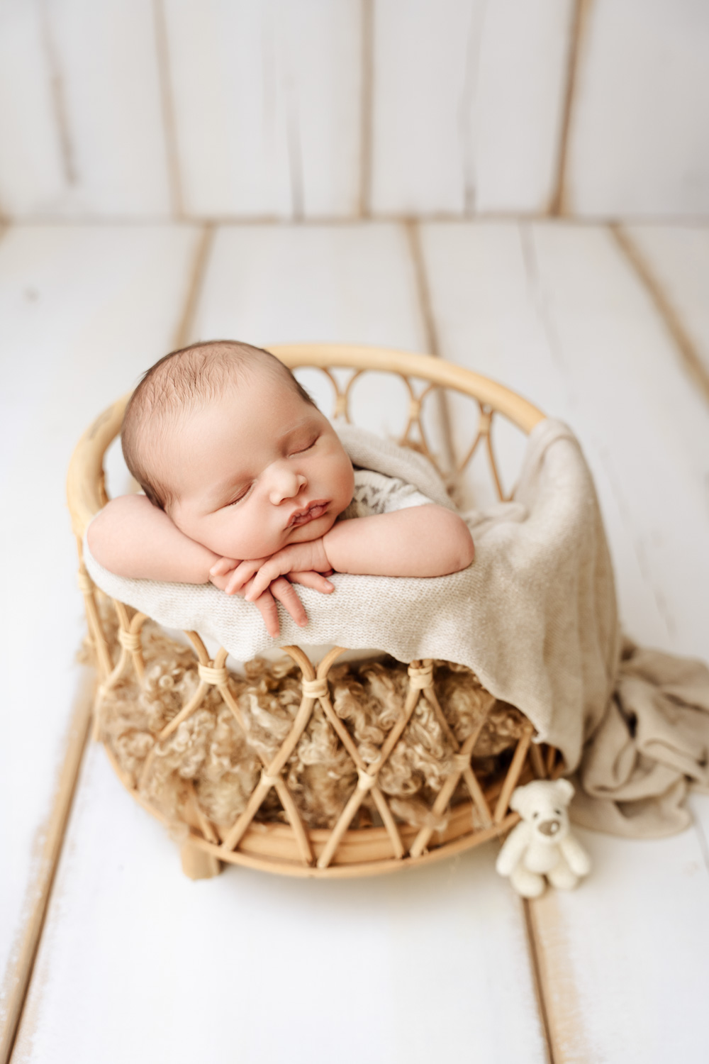 Neugeborenes positioniert in der Chin-on-hands Pose im Boho-Stil