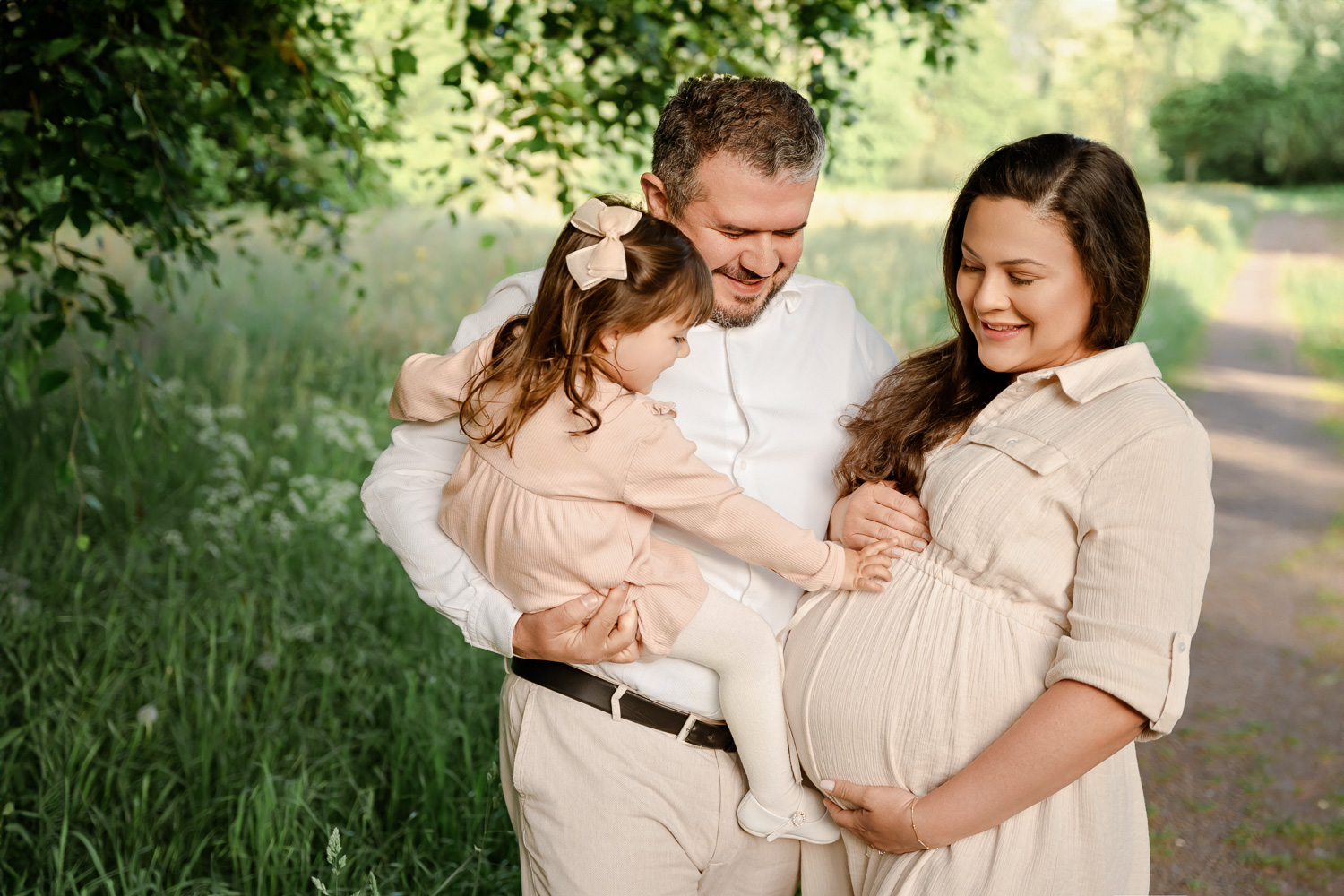 Familienfoto beim Babybauchshooting in Hamburg vor einer Wiese mit Geschwisterchen
