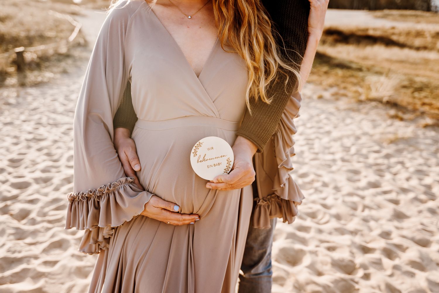 Werdende Mama beim Schwangerschaftsshooting in Hamburg in einem grünen Babybauchkleid in den Boberger Dünen bei Sonnenuntergang