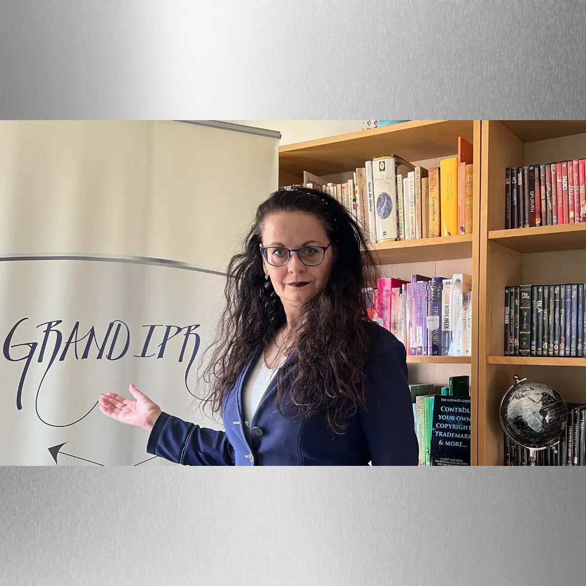 Image of Céleste between her colour coded book / DVD ase and banner with hand twoard banner palm up