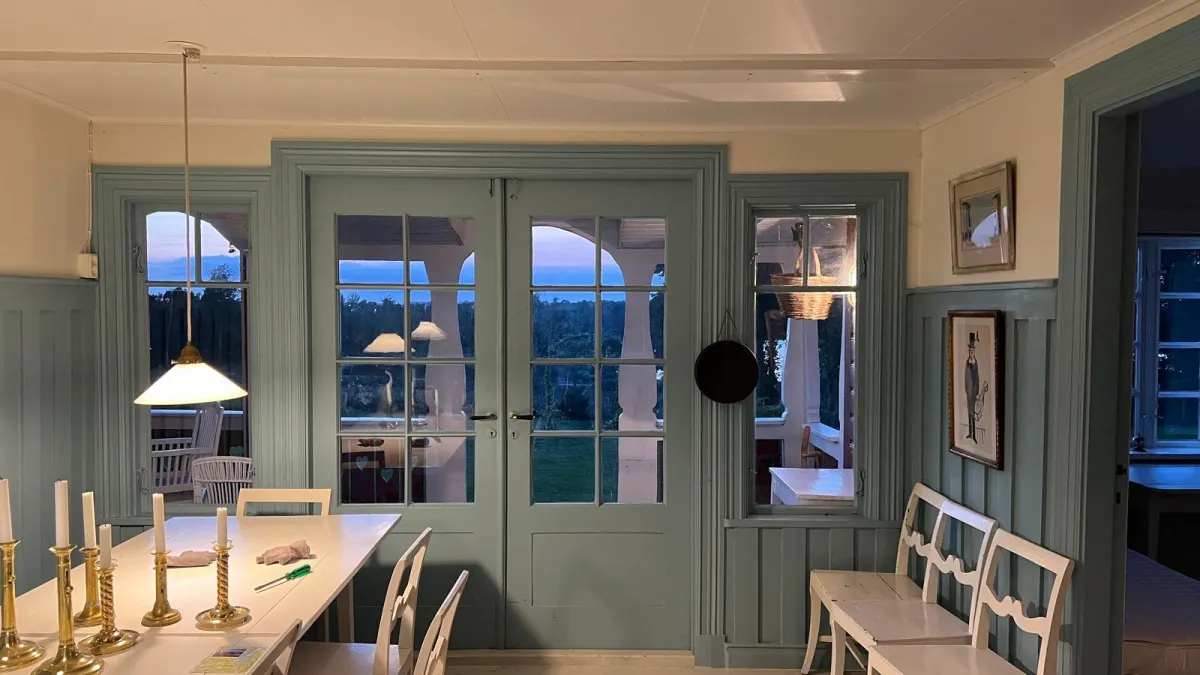 Swedish estate dining hall overlooking Lake Bolmen at twilight