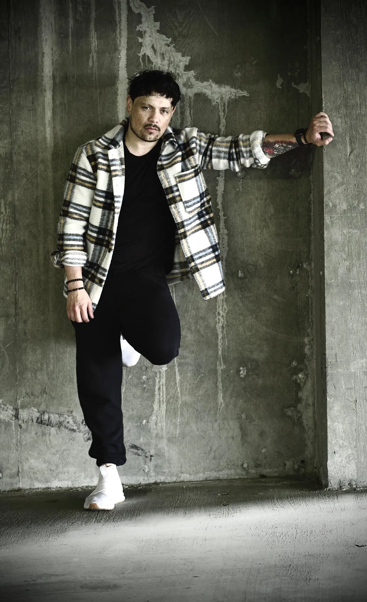man leaning on concrete wall