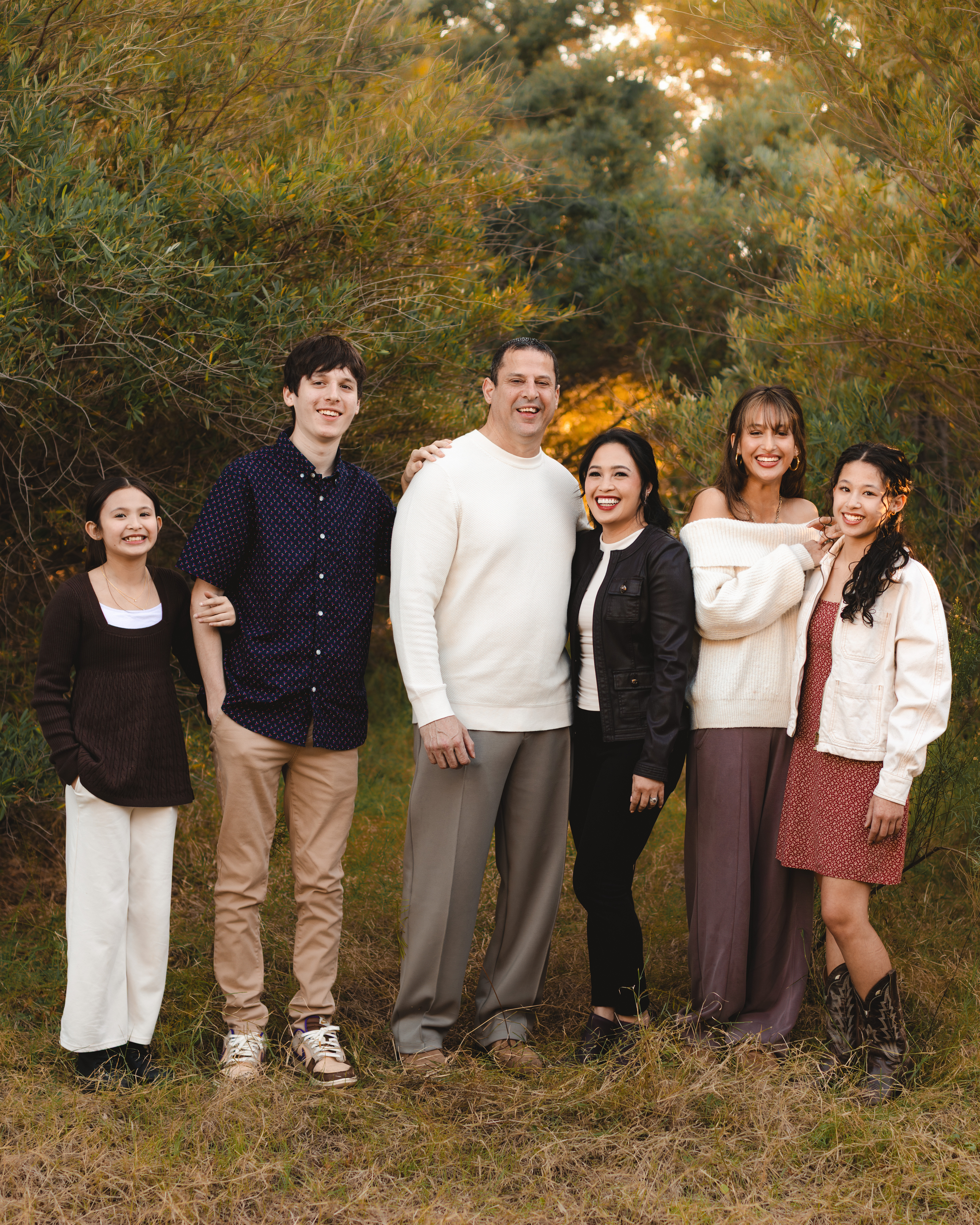 Family of six portrait taken at golden hour with desert trees in the background in Gilbert, Arizona by Andria May Photography