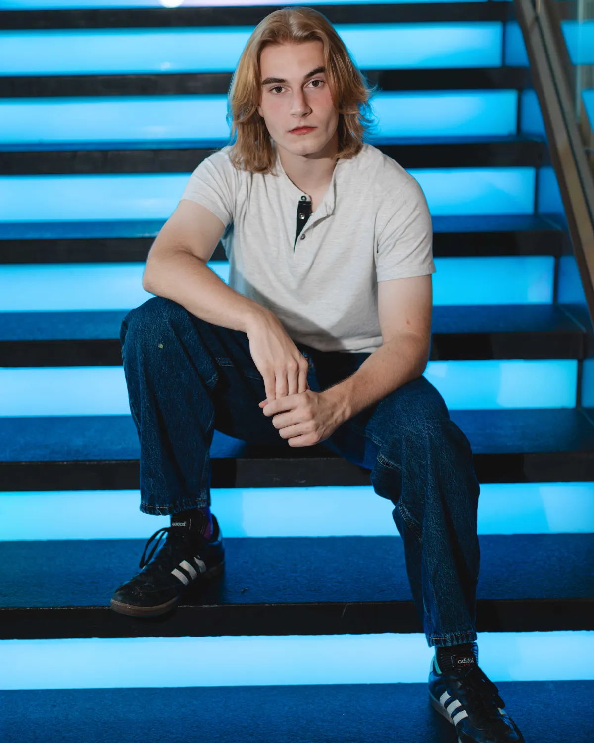 High school senior guy sitting on glowing blue stairs, Gilbert senior photographer