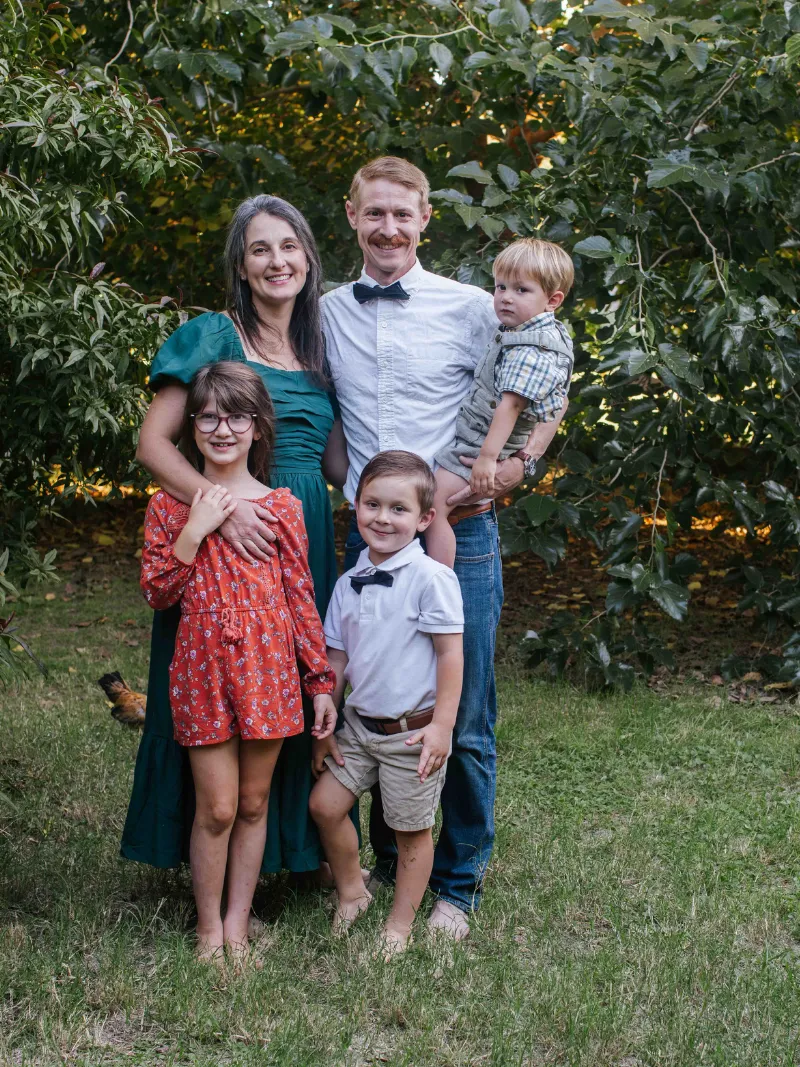 Family of five posing together outdoors during a fall-toned family portrait session in Gilbert, Arizona taken by Andria May Photography