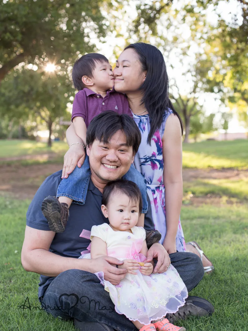 Dad and mom holding their two young children during an outdoor family photography session in Chandler, AZ taken by Andria May Photography