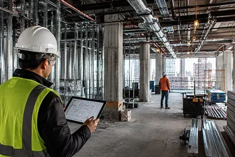 NYC DOB Special Inspections professional comparing construction progress with approved building plans on site