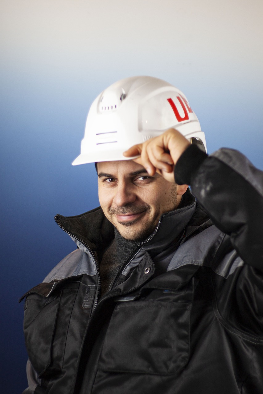 Smiling Texas contractor tipping hard hat — showcasing the confidence that comes with proper workers comp insurance coverage.
