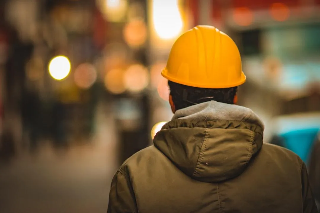 Texas contractor in hard hat surveying job site — highlighting the importance of workers comp insurance.