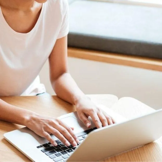 Woman's hands typing on a laptop, symbolizing client Vanessa Bond’s testimonial on Kim Roth's efficient VIP Day service for website and automation setup.