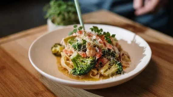 Indulge in a delicious and healthy pasta dish layered with nutrient-rich broccoli and succulent shrimp.