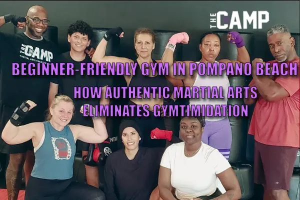 Diverse group of adult members and coach smiling together in boxing wraps at The Camp MATC, a beginner-friendly gym in Pompano Beach.