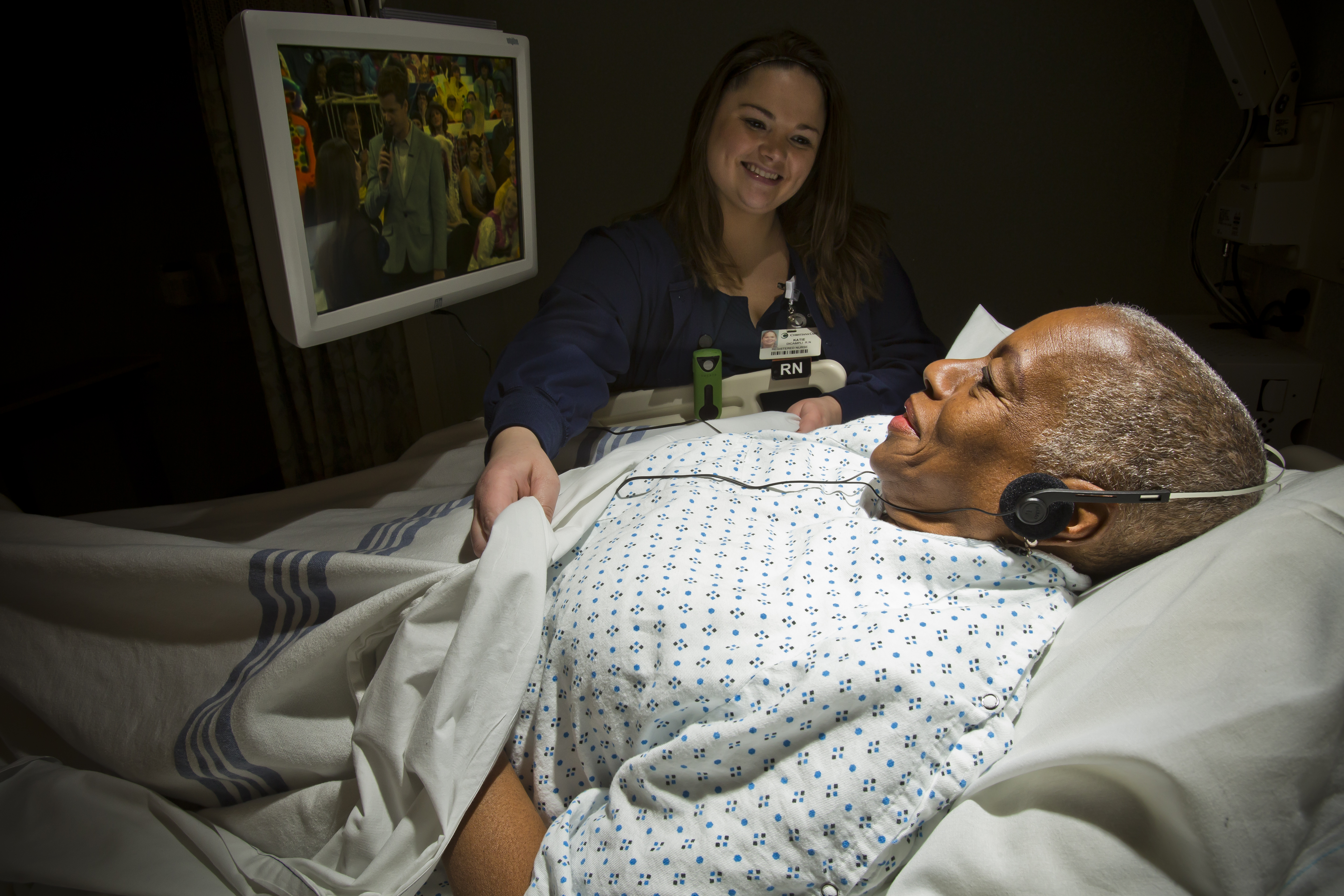 Doctor administers injection to patient in hospital room.