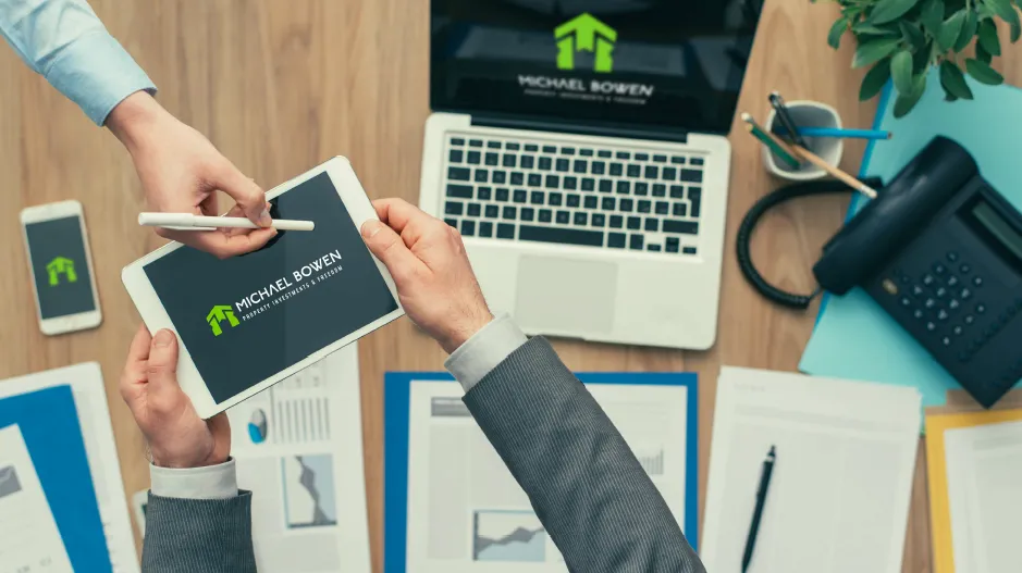 Clean flat-lay of a branded speaker pack document and tablet showing Michael Bowen's website mock, natural light, neutral textured background, professional editorial style, no people, atmospheric and minimal.