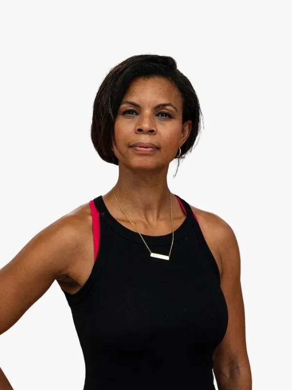 An African American woman with long curly hair swept to the side with a smile on her face