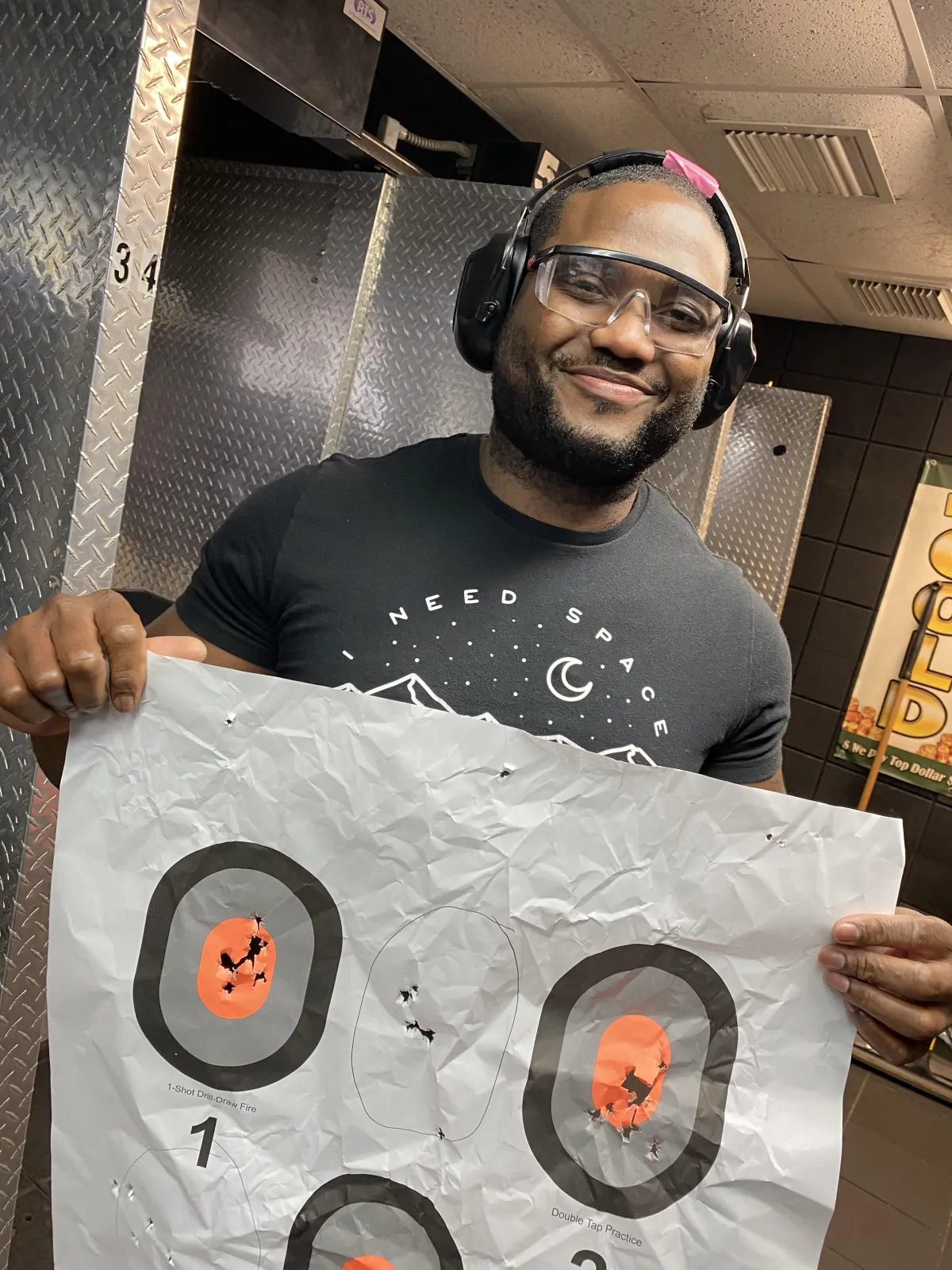 Male student holding target at gun range