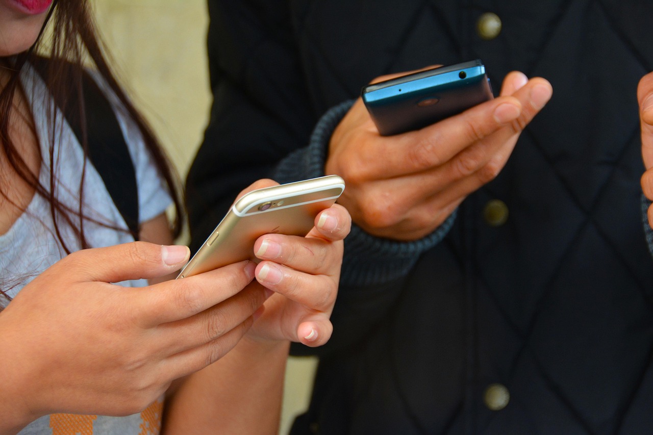 Two People texting with mobile phones