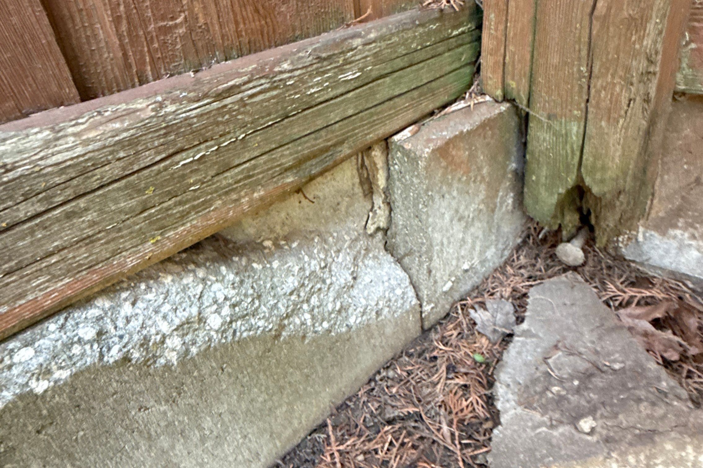 Concrete cracking and fence displacement observed during foundation inspection in Clive, Iowa