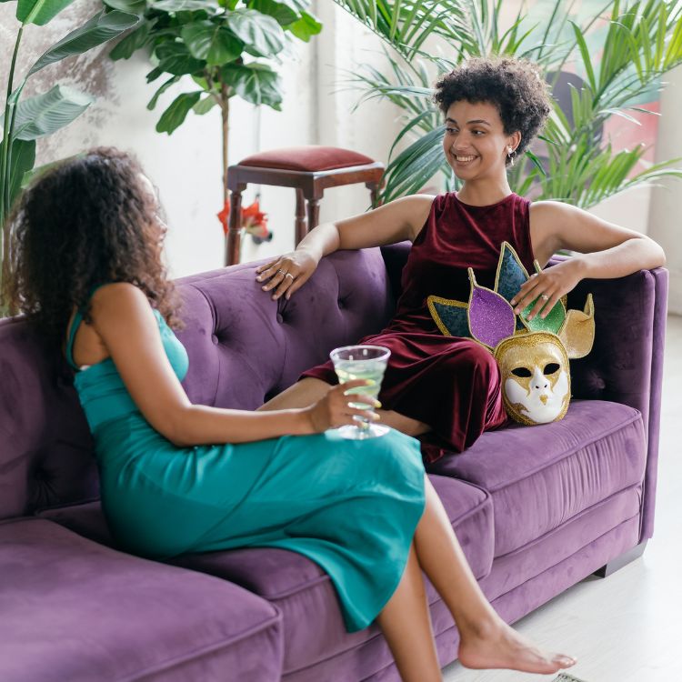 two women relaxing on a sofa chatting