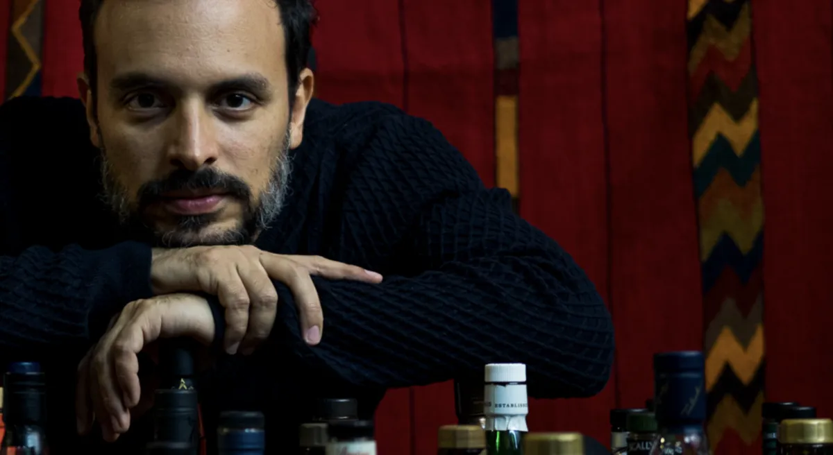 Tres botellas de whisky distintas sobre una mesa, representando la neutralidad y variedad.