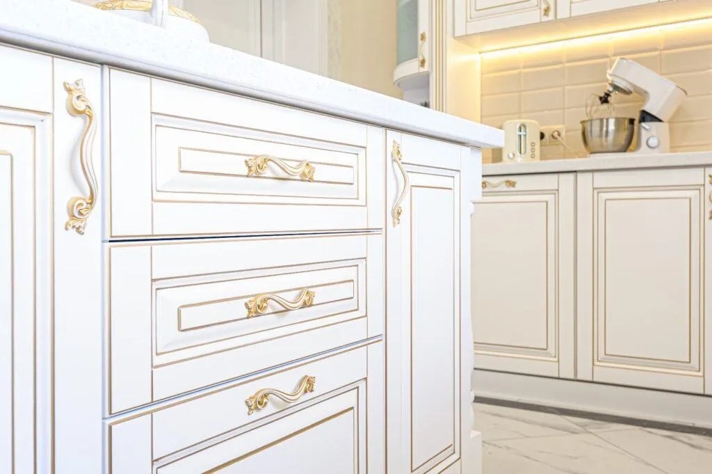 Close-up of luxury white and gold custom cabinetry with ornate handles — elegant craftsmanship by B&Y Reno Corp."