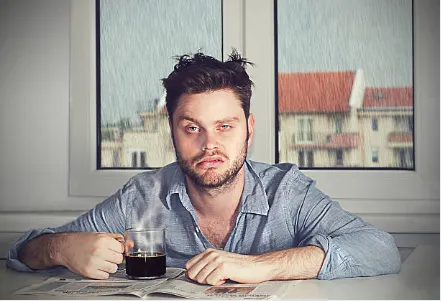 Tired single father drinking coffee while balancing work, parenting, and dating
