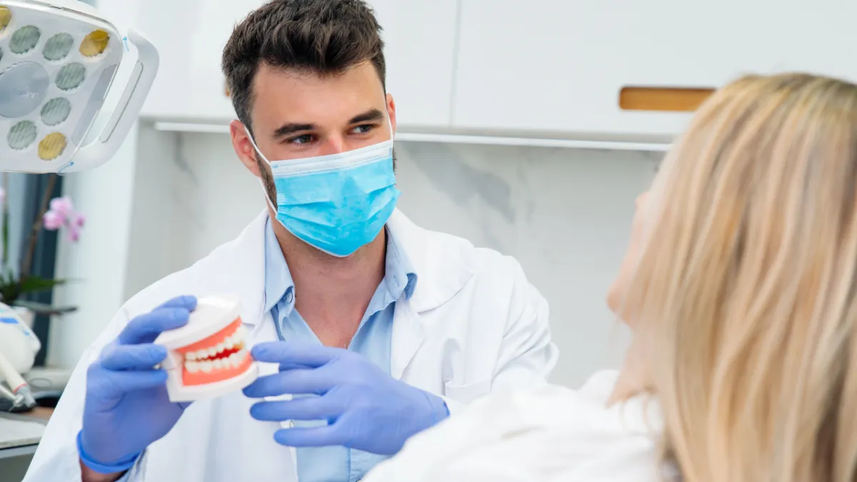 Dentist explaining oral health to a patient, illustrating the connection between dental care and heart disease prevention