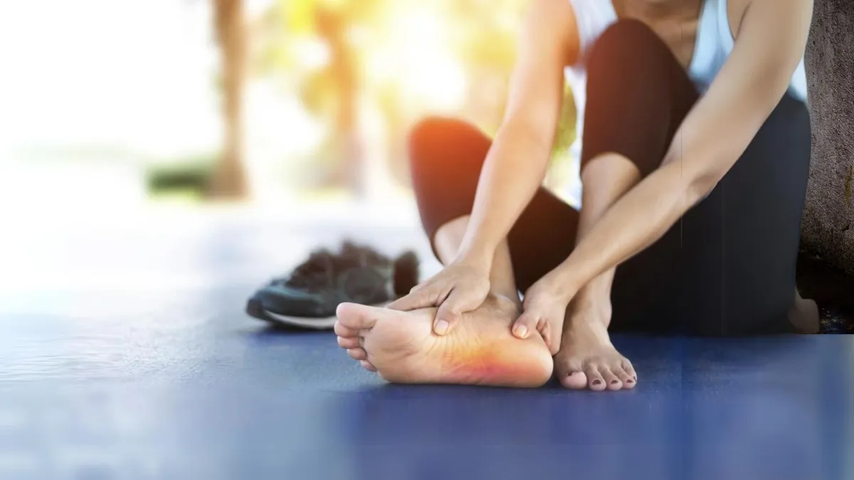 Woman in pain holding her foot.