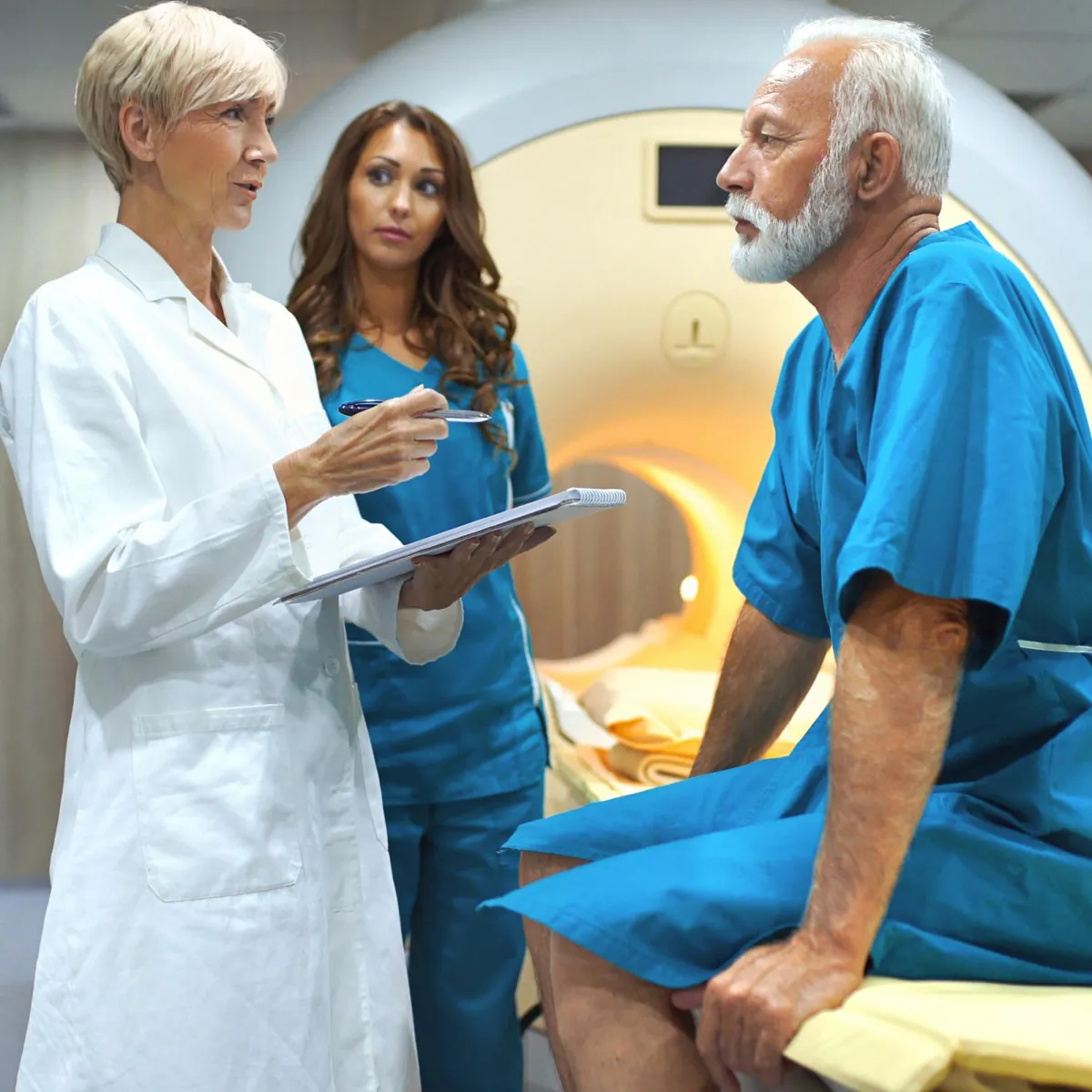 A doctor and patient are standing in front of a large MRI machine, preparing for a medical scan.