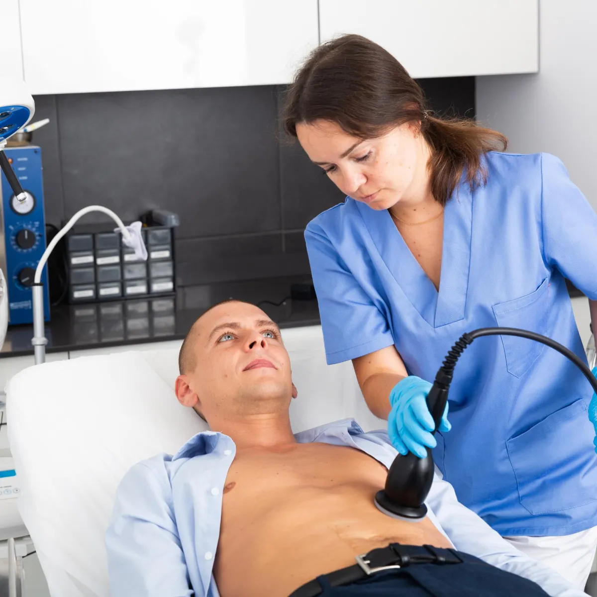 A doctor is using an ultrasound machine to examine a patient's abdomen.