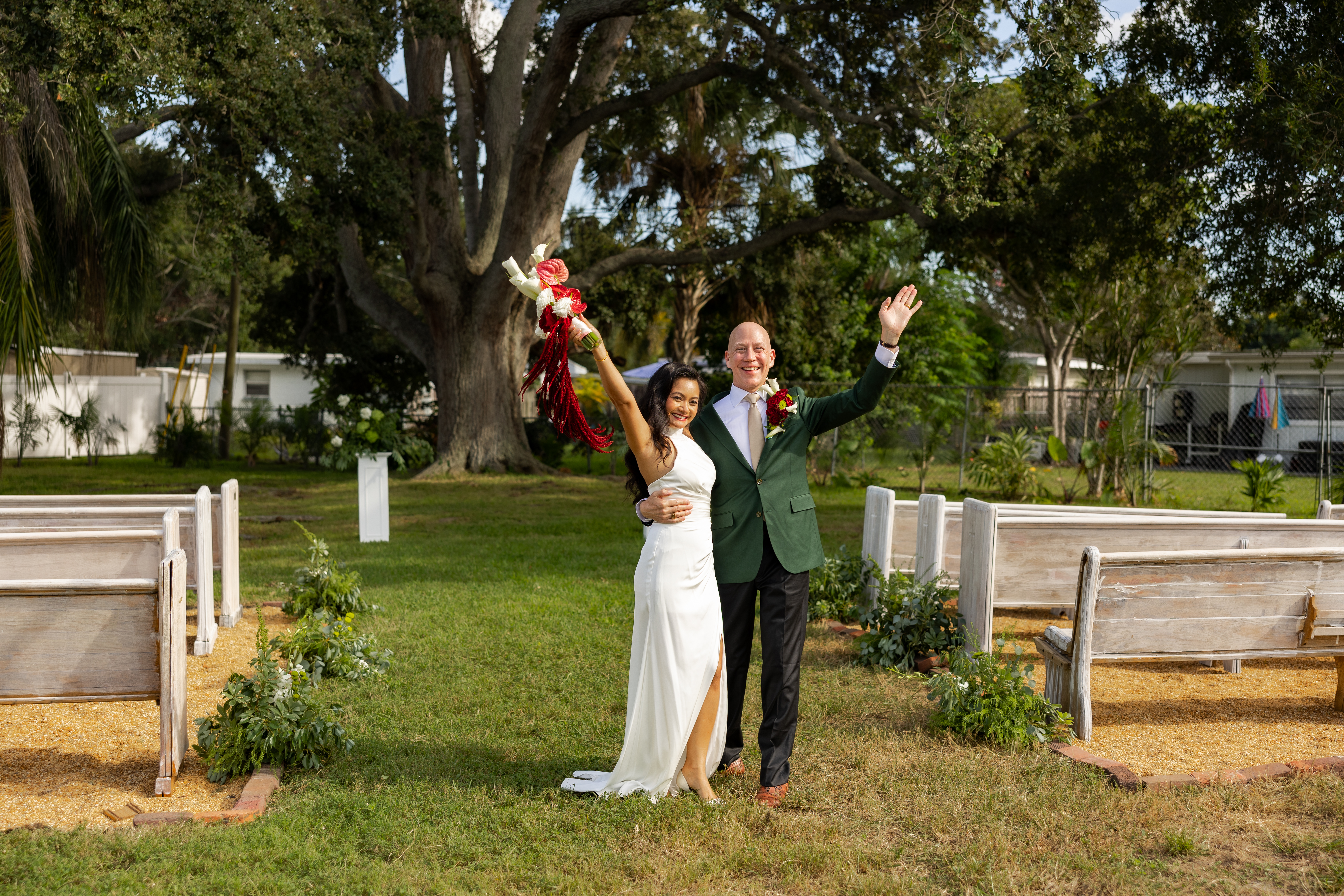 man in black suit holding white flower bouquet