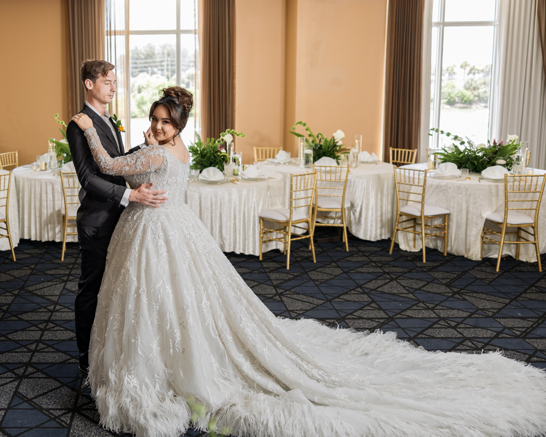 A wedding party on a balcony inside a grand building.