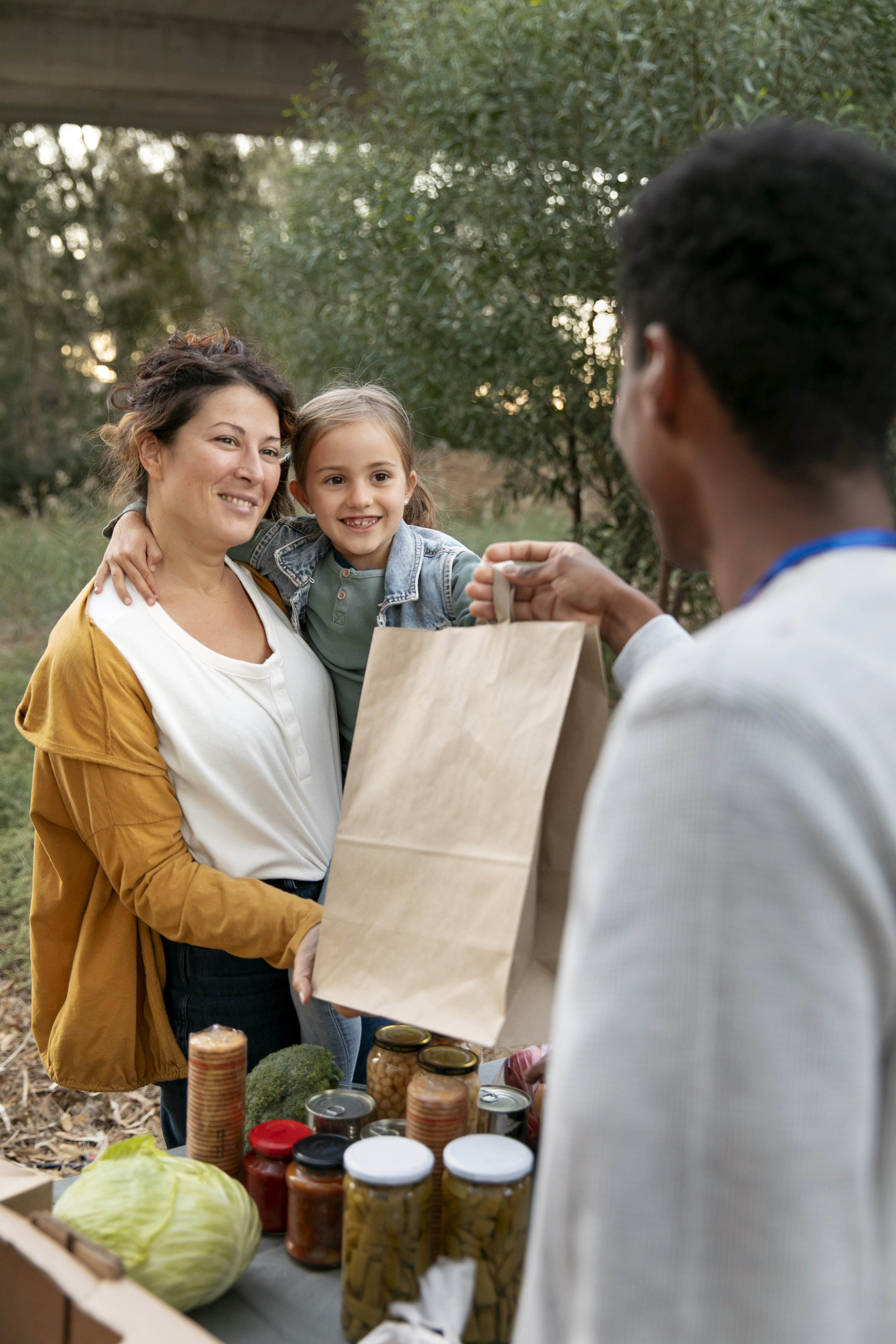 Community volunteer providing groceries to a family at a nonprofit outreach event