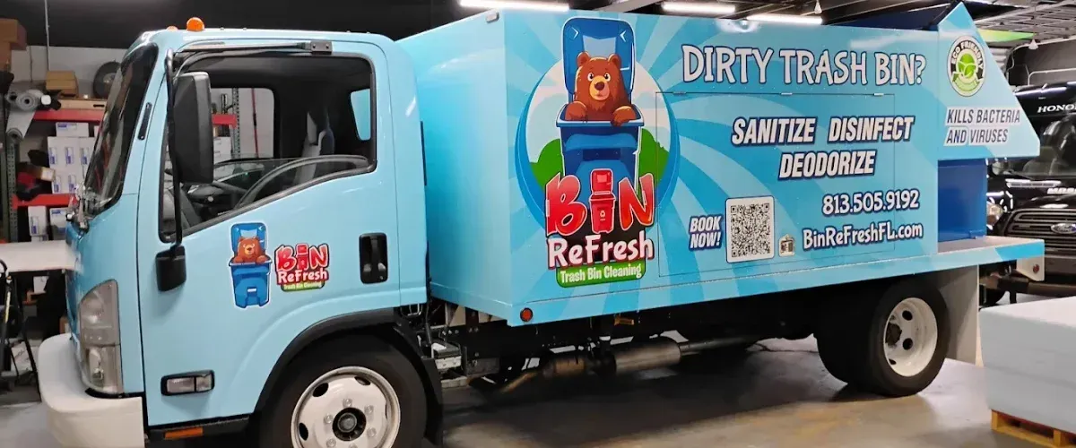 Bin Refresh trash can cleaning truck parked inside garage for maintenance
