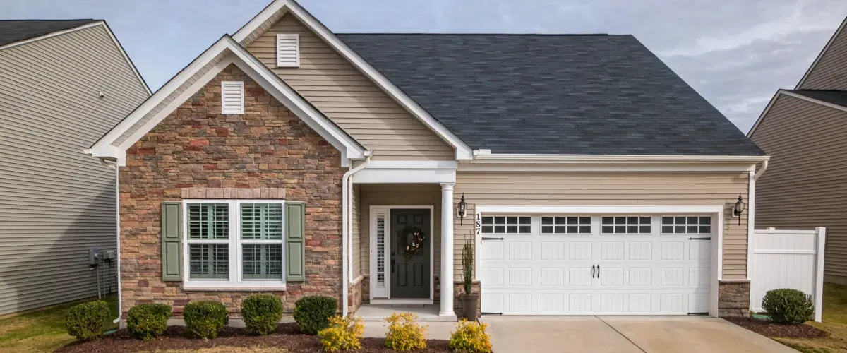 Modern suburban home with stone front and white garage door.
