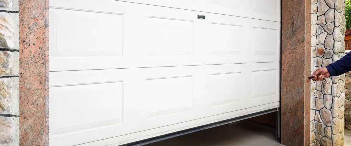 Close-up of a modern white garage door exterior with remote control operation.