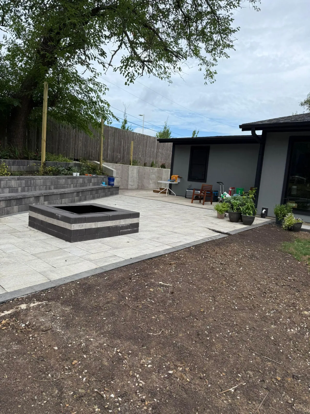Custom-built wooden deck and stone patio by Wilmer's Landscaping in KS & MO