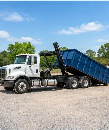 Roll-off truck unloading a dumpster