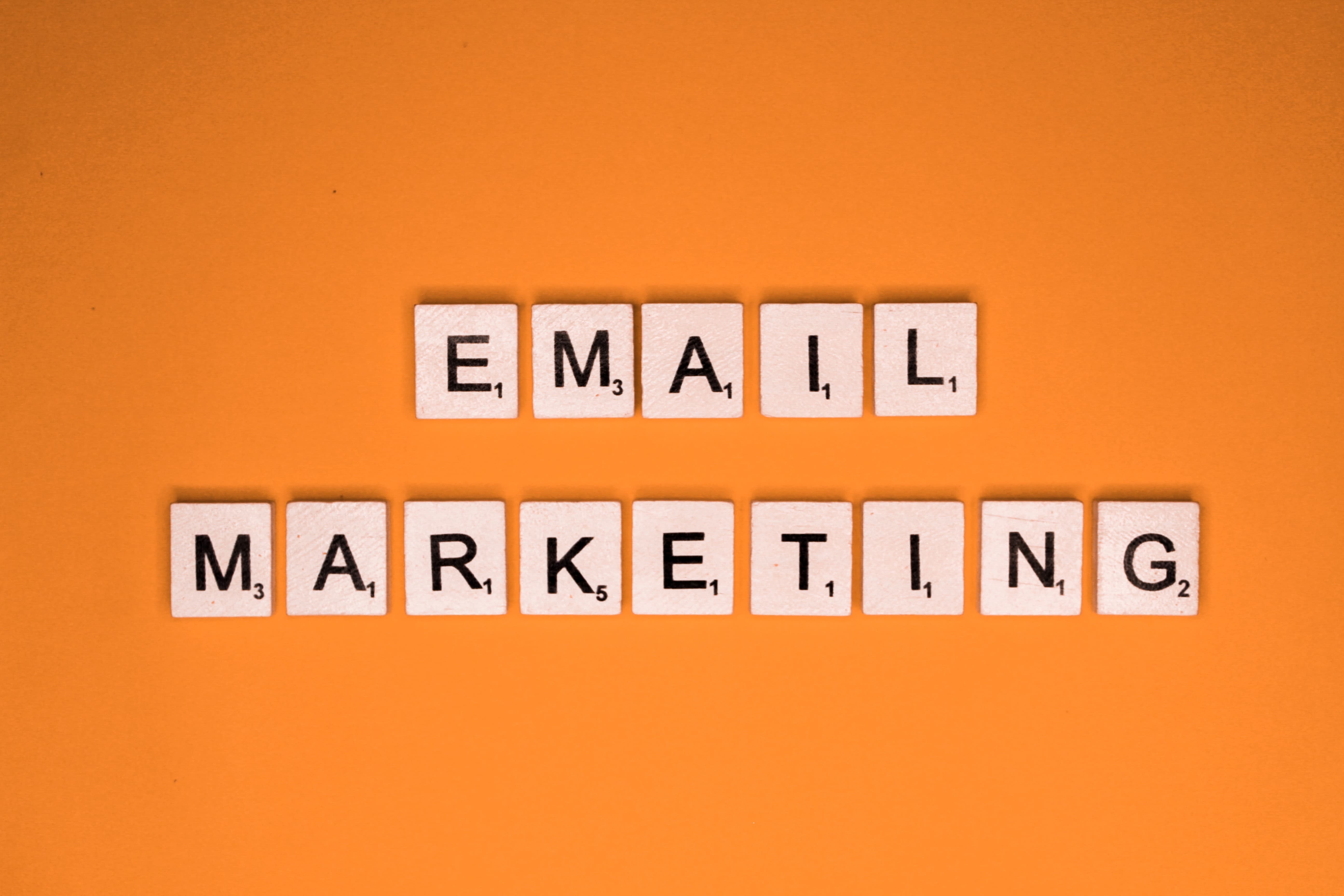 Scrabble tiles spelling “Email Marketing” on an orange background.