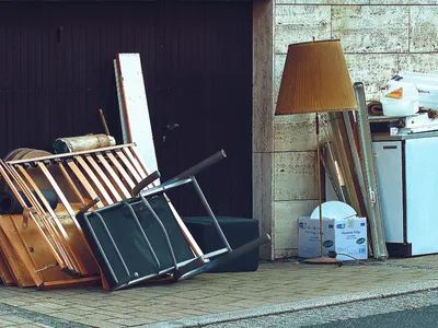 Bedroom furniture in a pile outside ready to be taken to trash.