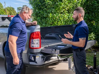 Discussing the days work behind a pickup truck.