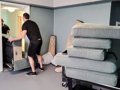 Movers taking out a sectional sofa.