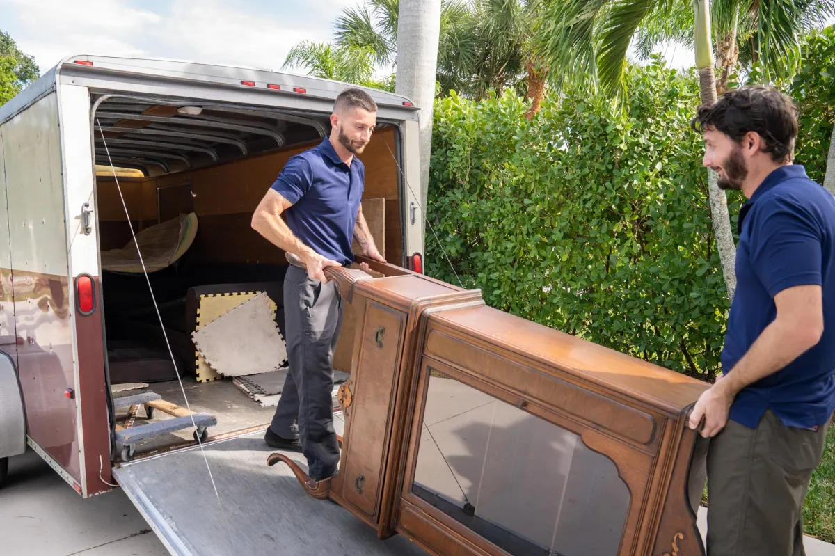 2 men moving furniture for an estate clean out.